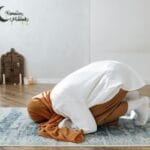 Kobieta w hidżabie modli się na dywanie w spokojnym, jasnym pokoju