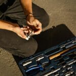 Zbliżenie na rękę wybierającą narzędzie z zestawu serwisowego na zewnątrz