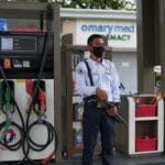 Ochroniarz w maseczce na stacji benzynowej pilnuje dystrybutorów paliwa