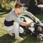 Mężczyzna przygotowuje kosiarkę do pracy w ogrodzie na wiosnę