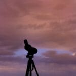 Sylwetka teleskopu na statywie na tle kolorowego zachodu słońca